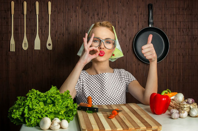 рыжая девушка в очках и косынке за кухонным столом