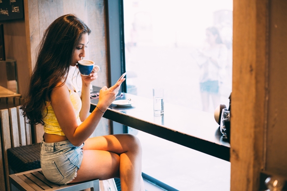 Young millennial woman texting in coffee shop - Get A Scorpio Man to Chase You
