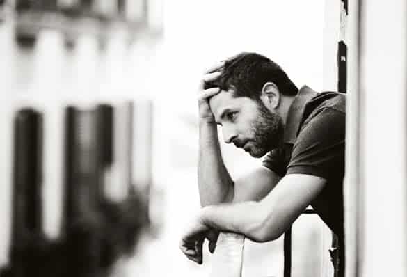 young handsome man outside at house balcony alone looking depressed